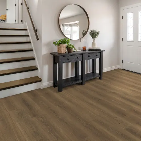 Wood-look vinyl flooring in a bright entryway with a staircase and console table | Kay Riley Carpet & Flooring