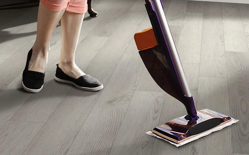 Person cleaning vinyl flooring with a vacuum cleaner | Kay Riley Carpet & Flooring